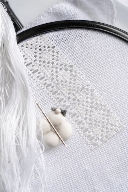 Practiciană cusând un motiv tradițional pe pânză